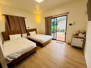 a bedroom with two beds and a sliding glass door at วังเหนือเมาน์เทนวิว-Wangnue Mountain View 