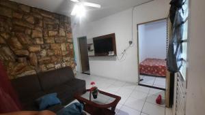 a living room with a couch and a stone wall at Casa verde temporada in São José da Barra