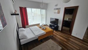 a bedroom with a bed and a table and a television at Luca Apartament in Bucharest