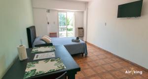 ein Zimmer mit einem Bett, einem Tisch und einem Fernseher in der Unterkunft Monoambiente en ubicación estratégica in Santa Fe