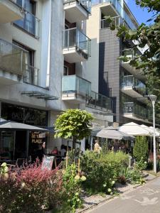 a building with tables and umbrellas in a garden at Apartament Luxon 2 in Kielce