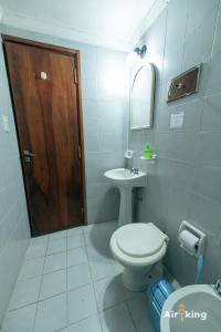ein Badezimmer mit Toilette und Waschbecken und einer Holztür in der Unterkunft Monoambiente en ubicación estratégica in Santa Fe