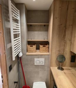 ein Bad mit WC und Korb an der Wand in der Unterkunft Le 1954 La Rosière in La Rosière
