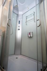 a shower with a glass door in a bathroom at Hotel Avión Air Damasco in Oncativo