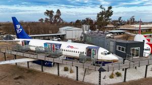 a plane is parked at an airport with a boarding ramp at Hotel Avión Air Damasco in Oncativo