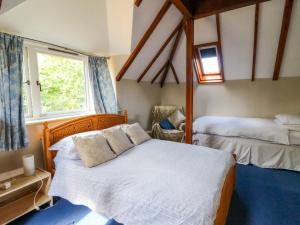 a bedroom with two beds and a window at Gaer Hall in Guilsfield