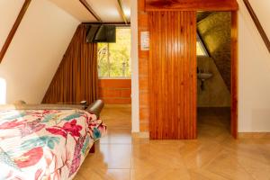 une chambre avec un lit et une salle de bain avec une fenêtre dans l'établissement Chalet Venus - Hospedaje Rural La Fortaleza, à Pacho