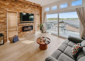 ein Wohnzimmer mit einer Couch und einer Ziegelwand in der Unterkunft Croft Farm Water Park in Tewkesbury