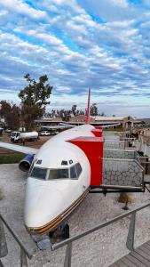 a red and white airplane sitting on the ground at Hotel Avión Air Damasco in Oncativo