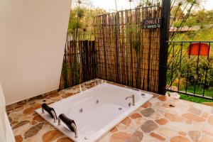 une baignoire dans une pièce avec une fenêtre dans l'établissement Chalet Venus - Hospedaje Rural La Fortaleza, à Pacho