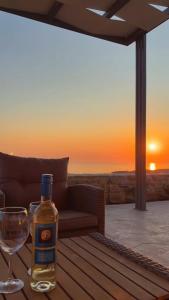 Eine Flasche Whisky steht mit einem Weinglas auf einem Tisch. in der Unterkunft Villa Sofita Komos View in Pitsidia