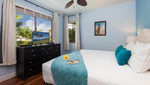 Schlafzimmer mit einem Bett, einem TV und einem Fenster in der Unterkunft TRANQUILITY VILLA Tranquil 2BR Kulalani Villa with Private Beach Club in Waikoloa + 46 Fotos