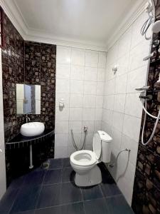 ein weißes Badezimmer mit Toilette und Waschbecken in der Unterkunft Misty Haven Homestay - Bungalow in Kuala Terengganu