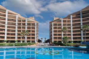 una piscina di fronte a un grande edificio di Sonoran Sun a Puerto Peñasco