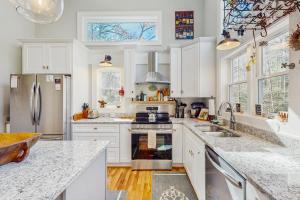 eine Küche mit weißen Schränken und Geräten aus Edelstahl in der Unterkunft Bibi's Creek Retreat in Boone