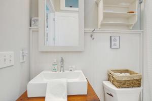 ein weißes Badezimmer mit Waschbecken und Spiegel in der Unterkunft Bibi's Creek Retreat in Boone + 14 Fotos