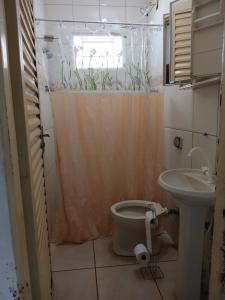 a bathroom with a toilet and a sink at Casa verde temporada in São José da Barra