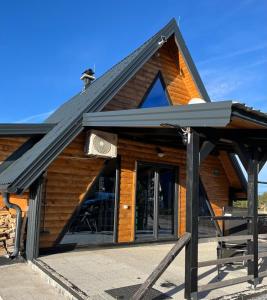 a building with a pitched roof with a large window at Vikendica A&J in Blidinje