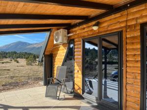 a porch with sliding glass doors and a chair at Vikendica A&J in Blidinje