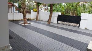 una acera de ladrillo con árboles y una valla en A Wonderful stay, en Kappil 4 fotos más