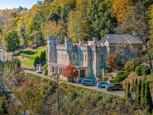 a large house with cars parked in front of it at Sqyrls Nest - Hot Tub, Pet Friendly, Screen Porch, Grill, Wifi, Fire Pit, Deck, View, Family Friendly, Game Room, Shuffle Board, Wood Stove in Berkeley Springs