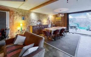 a living room with a dining room table and chairs at Superbe Maison Avec Piscine in Mombrier