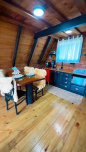a kitchen with a wooden floor and a wooden table at Chalé Recanto da Coruja in Alfredo Wagner +25 photos