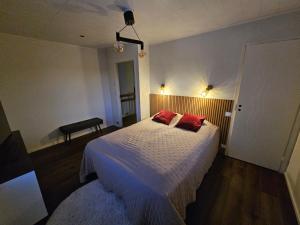 une chambre avec un lit avec deux oreillers rouges dessus dans l'établissement Frozen Villa Lapland, à Rovaniemi