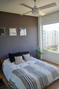 a bedroom with a large bed with a ceiling fan at 2 ambientes con Amenities y Vista al Río in Vicente López +69 photos