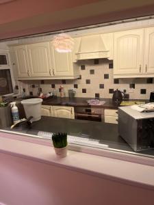 a kitchen with white cabinets and a counter top at King Edward house in Rhymney