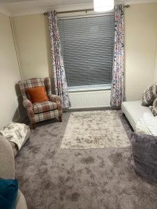 a living room with a couch and a chair and a window at King Edward house in Rhymney +2 photos