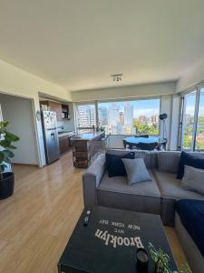 ein Wohnzimmer mit einem Sofa und Stadtblick in der Unterkunft 2 ambientes con Amenities y Vista al Río in Vicente López
