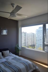 ein Schlafzimmer mit einem Bett und einem großen Fenster in der Unterkunft 2 ambientes con Amenities y Vista al Río in Vicente López
