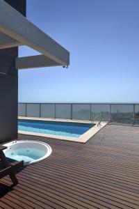 einen Whirlpool auf einer Terrasse neben einem Pool in der Unterkunft 2 ambientes con Amenities y Vista al Río in Vicente López