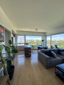 a living room with a couch and a large window at 2 ambientes con Amenities y Vista al Río in Vicente López