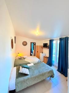 Schlafzimmer mit einem Bett und blauen Vorhängen in der Unterkunft Maison Bon Séjour in Livry-Gargan