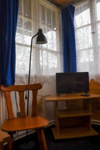 ein Schreibtisch mit einem Laptop und einer Lampe neben einem Fenster in der Unterkunft Pension Vyhlídka in Lužná
