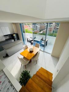 a living room with a wooden table and chairs at Penthouse Duplex Apartment en Cali, Ciudad 2000 in Cali