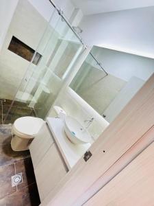 a bathroom with a toilet and a glass shower at Penthouse Duplex Apartment en Cali, Ciudad 2000 in Cali