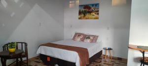 ein Schlafzimmer mit einem Bett und einem Bild an der Wand in der Unterkunft Pousada Solar Encanto do Marajó in Soure
