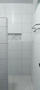 ein Badezimmer mit Dusche und weiß gefliesten Wänden in der Unterkunft Pousada Solar Encanto do Marajó in Soure