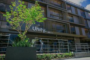 ein Bürogebäude mit einem Universitätsschild in der Unterkunft Unity #122 - Apartamento por Carpediem in Penha