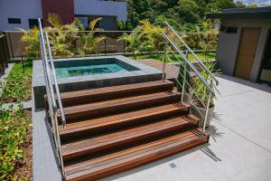 eine Holztreppe zum Pool in der Unterkunft Unity #122 - Apartamento por Carpediem in Penha
