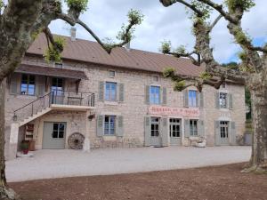 ein altes Steingebäude mit einer Treppe davor in der Unterkunft Gîtes et Chambre d'Hôtes Le Vieux Chêne in Lhuis