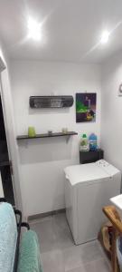 une pièce blanche avec un bureau et un clavier sur une étagère dans l'établissement Studio Lindois, à Lalinde