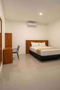 MeulabohNADA Homestay的带床和椅子的卧室