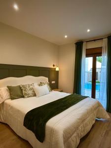 a bedroom with a large bed and a window at La villa de Ramona in Argamasilla de Alba