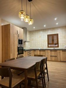 a large kitchen with a wooden table and chairs at La villa de Ramona in Argamasilla de Alba