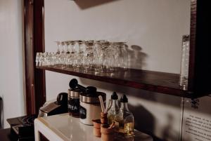 a row of glasses on a shelf above a stove at Casa Iager - Vama Buzaului in Acriş