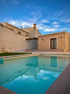 a swimming pool in front of a house at La villa de Ramona in Argamasilla de Alba